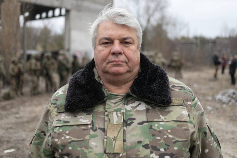 A gray-haired man in fatigues