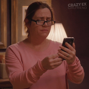 GIF of a woman looking at her phone, horrified