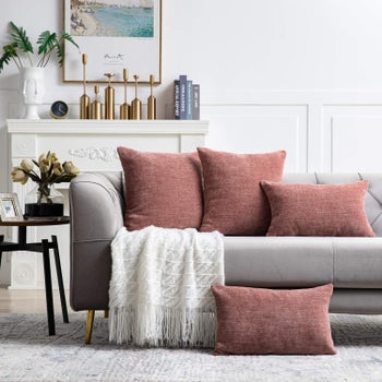 a couch with various sized orange pillows