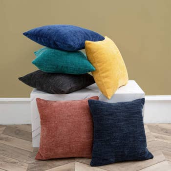a stack of pillows in different colors