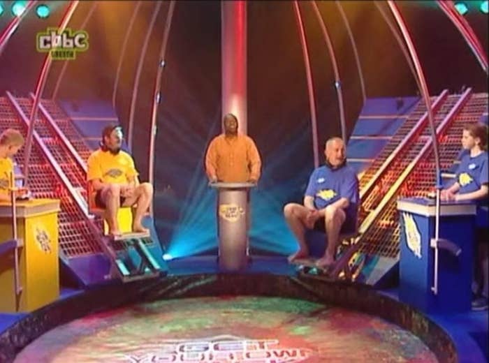 dave benson philips and four contestants standing in front of the gunge tank