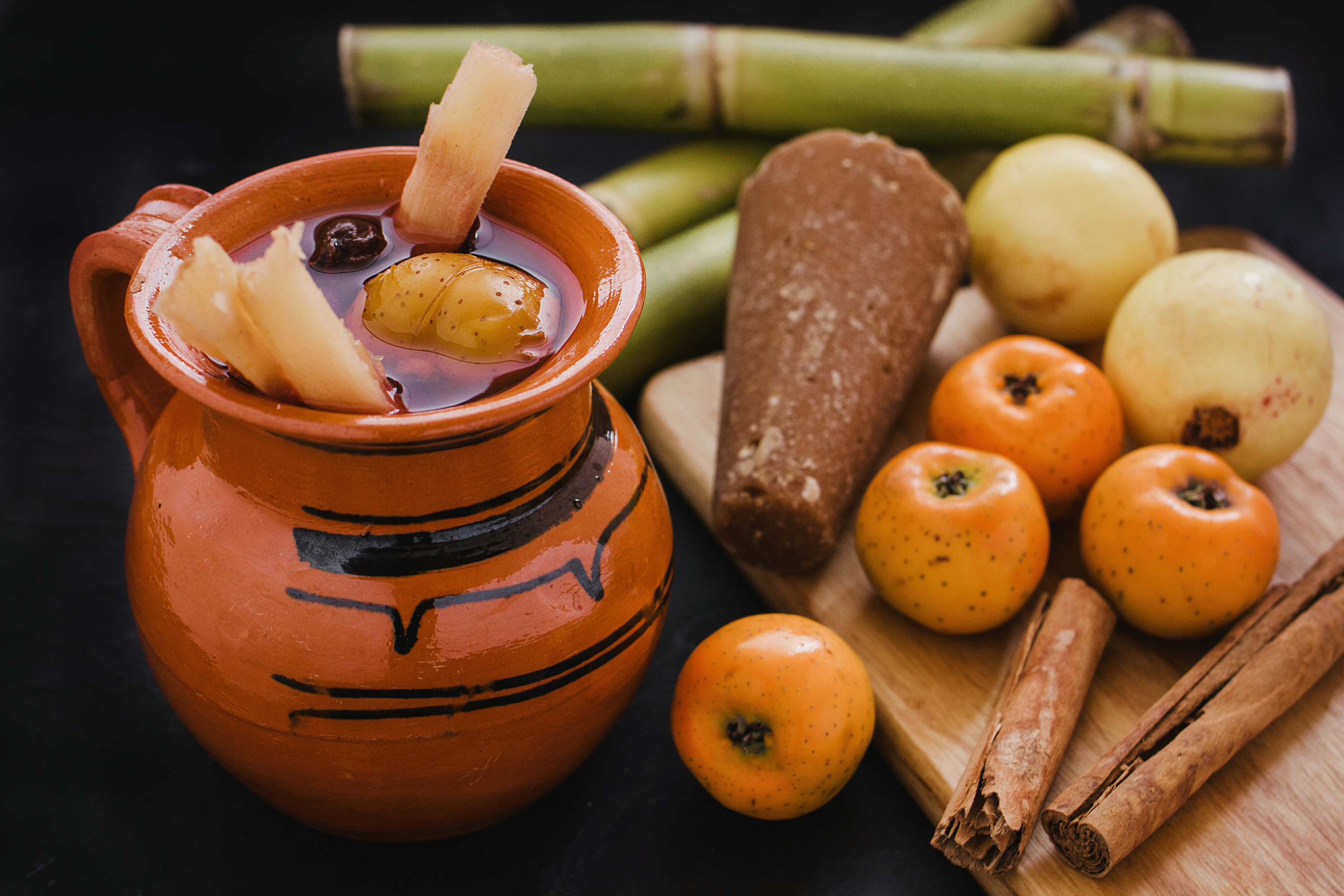Mug of Ponche Navideño with fruit and sugarcane sticks