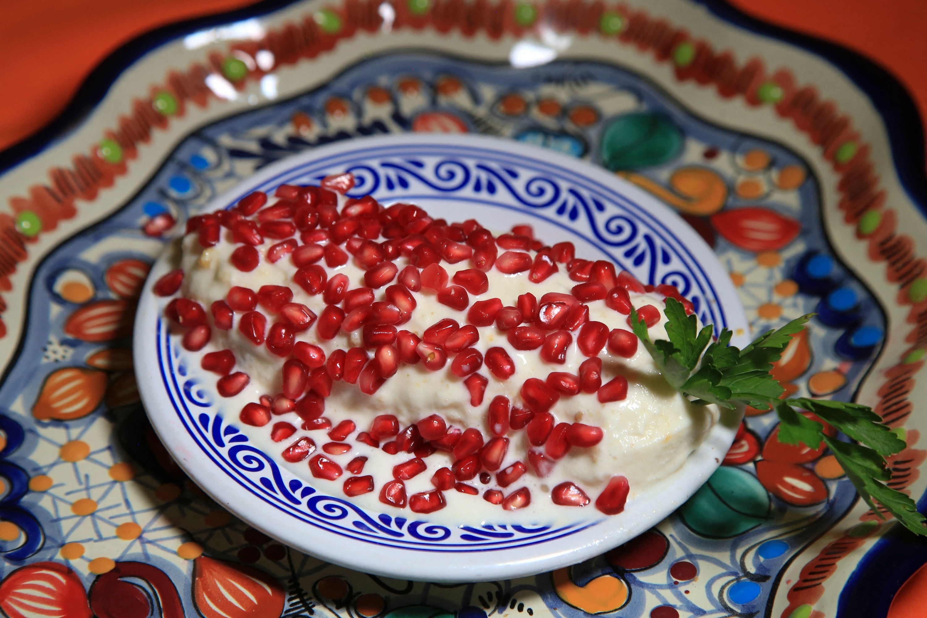 Stuffed poblano chile with nogada sauce and pomegranate seeds