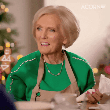 Mary Berry on Great British Bake Off holding up a gingerbread cookie