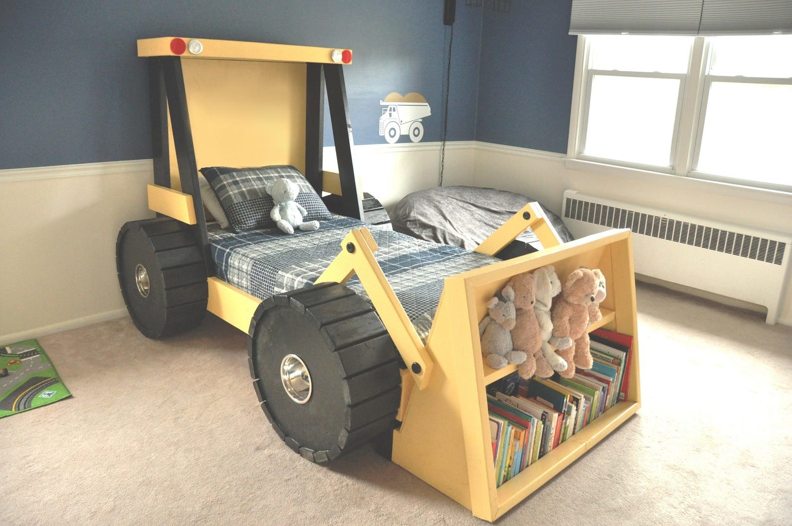 bed shaped like a construction truck with a bookshelf on the front