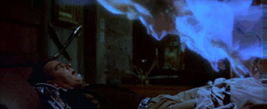 the ghost looks at Ray as he lies down and starts to float down his body as Ray looks up in shock