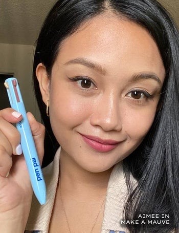 Model holding the pen after using it to create her full face
