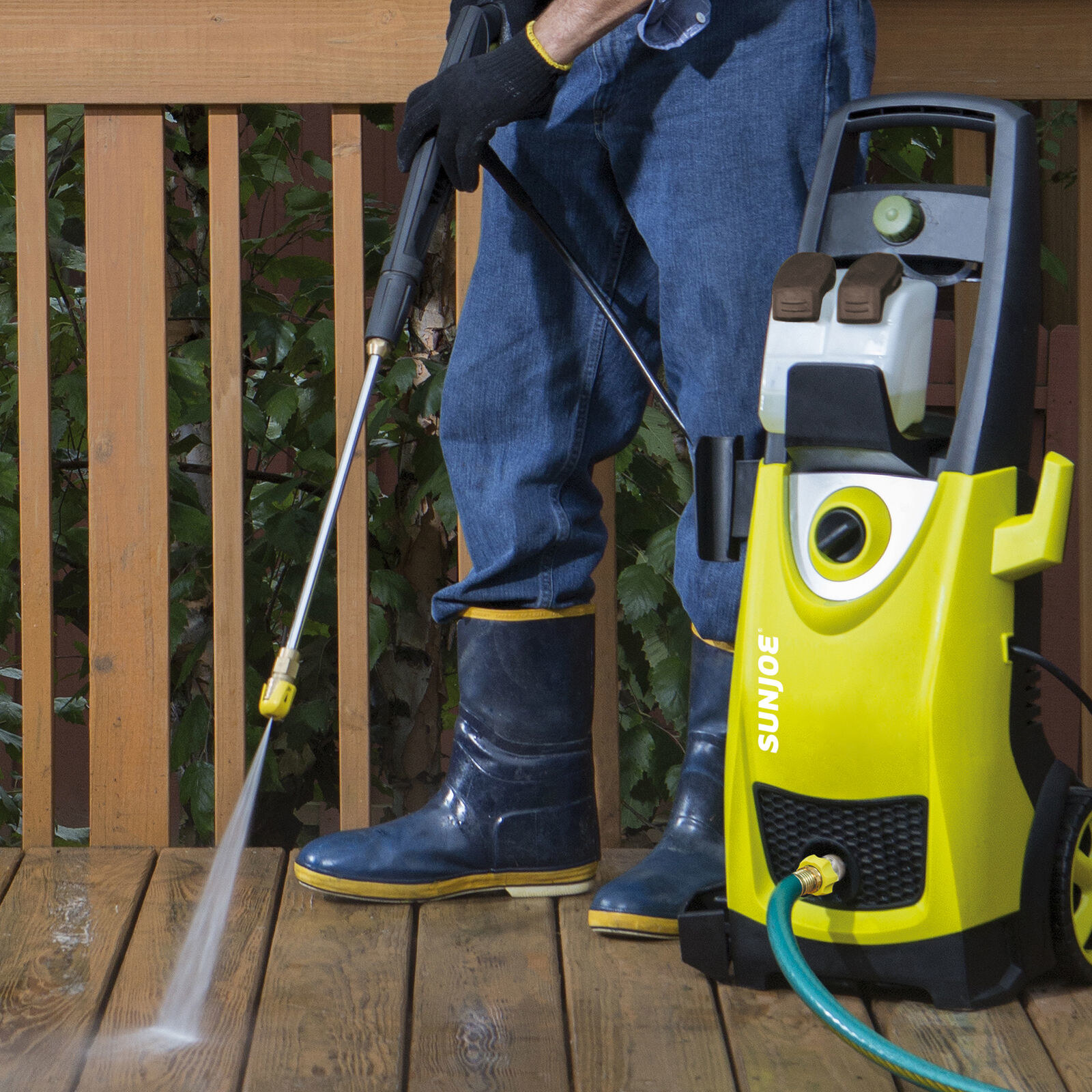 Man with pressure washer on patio