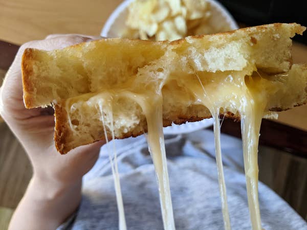 Melted cheese pouring out of a grilled cheese sandwich