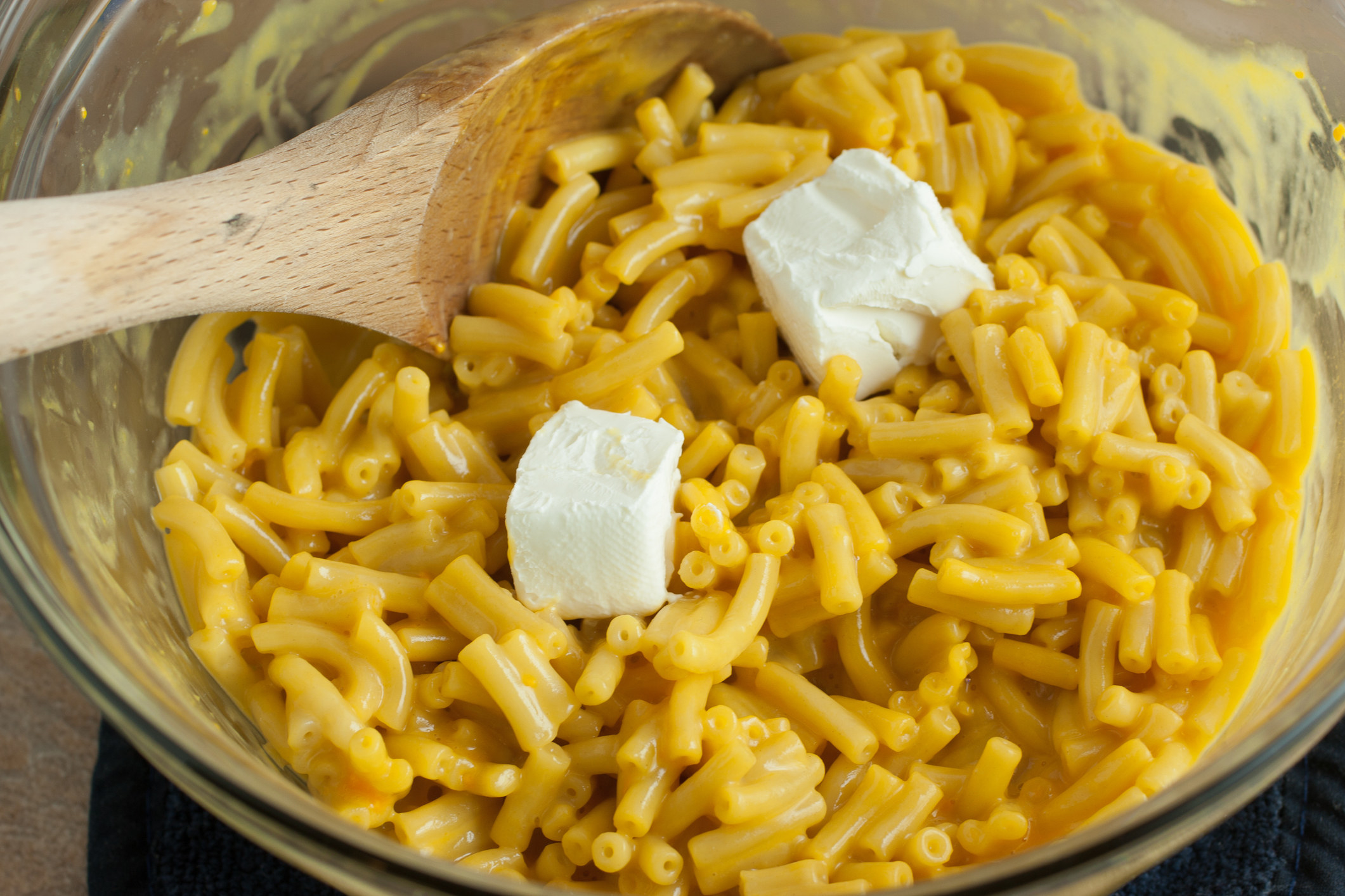 Macaroni and cheese in a bowl with cream cheese chucks.