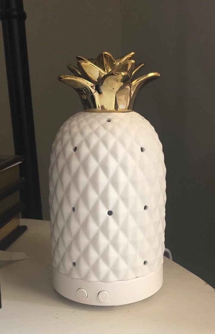 reviewer image of the pineapple shaped oil diffuser on a shelf