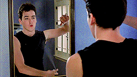 John Cusack as Lloyd Dobler furiously sprays deodorant into his armpit as he looks at himself in the bathroom mirror