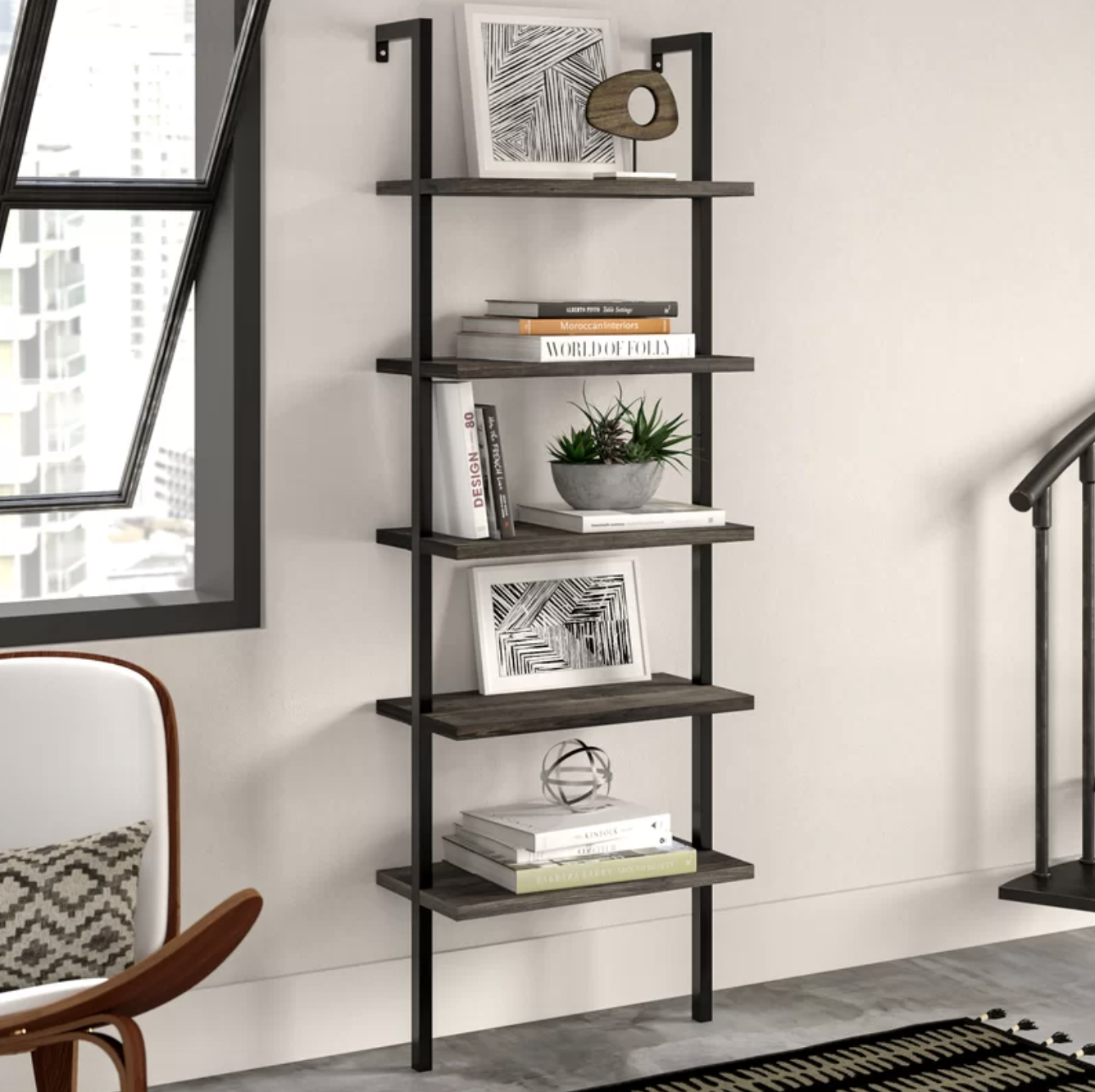 the black and wood ladder bookcase showcasing books and decor