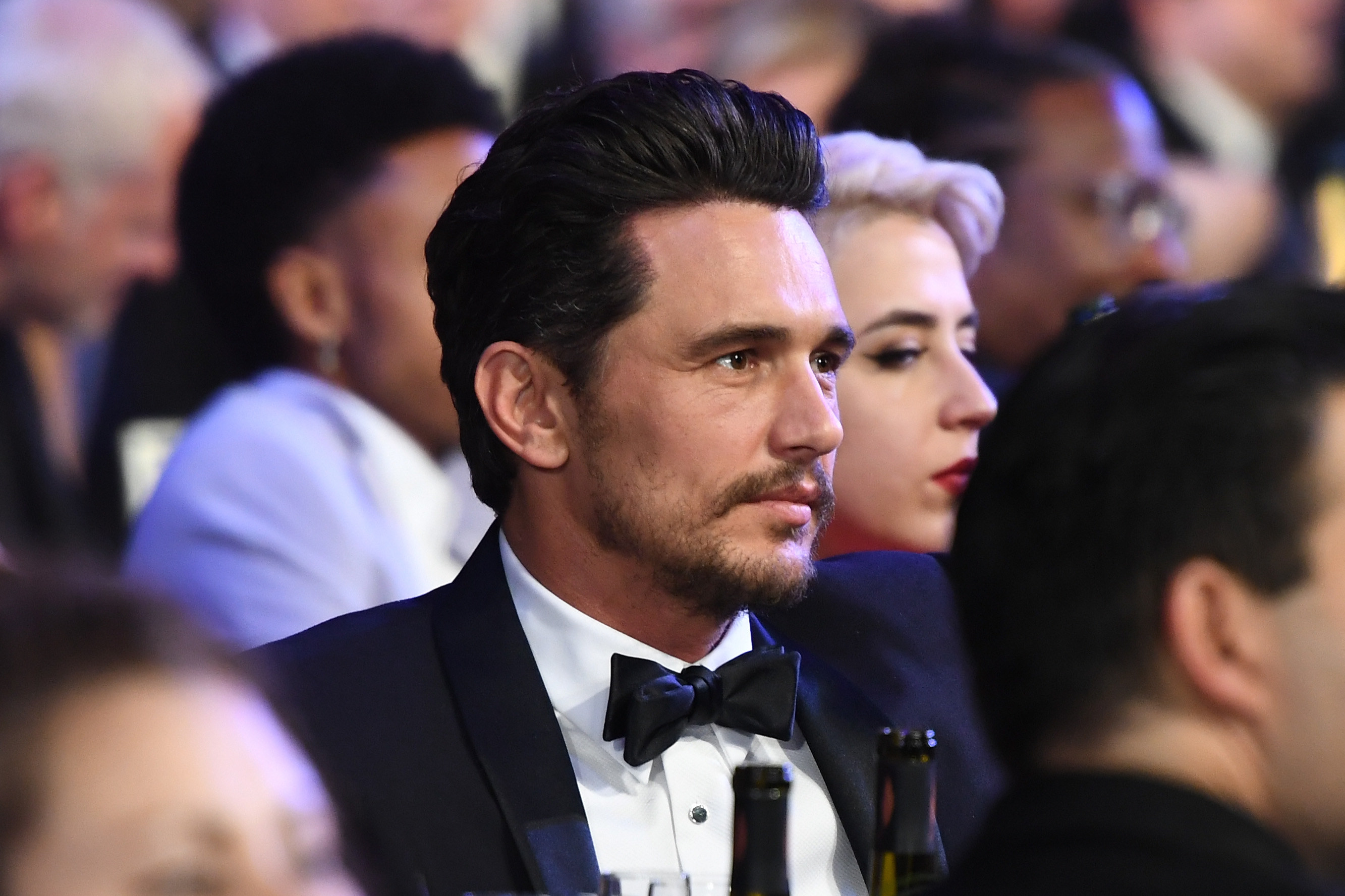 James wearing a tuxedo and sitting at a table during an event