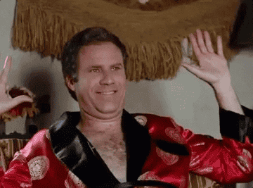 Will Ferrel in a red silk robe happily dancing laying on the couch