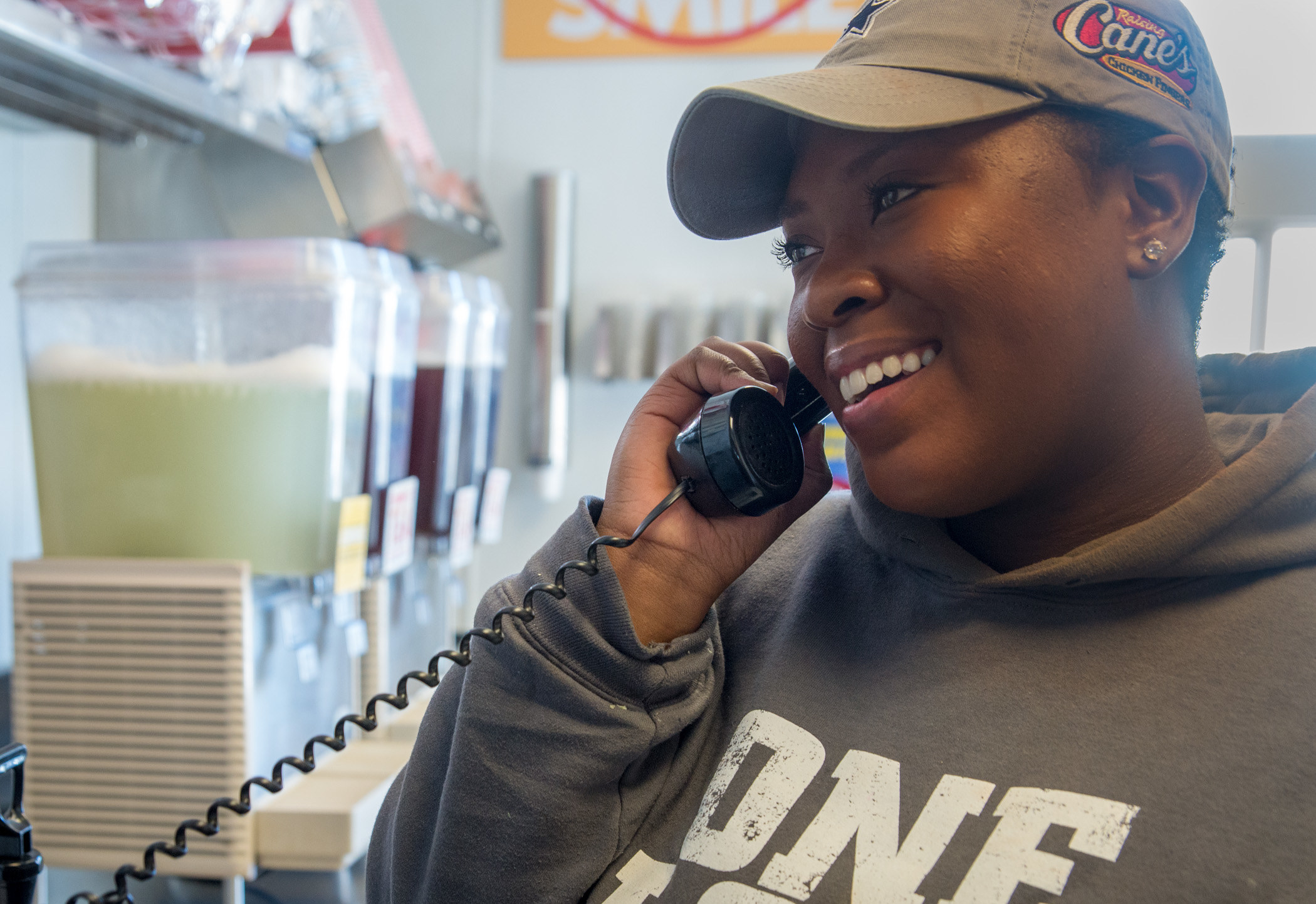A Raising Cane&#x27;s employee talking on the phone.