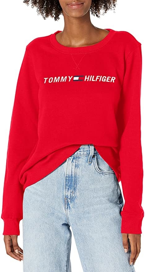 a model wearing a sweatshirt with the Tommy Hilfiger logo on it