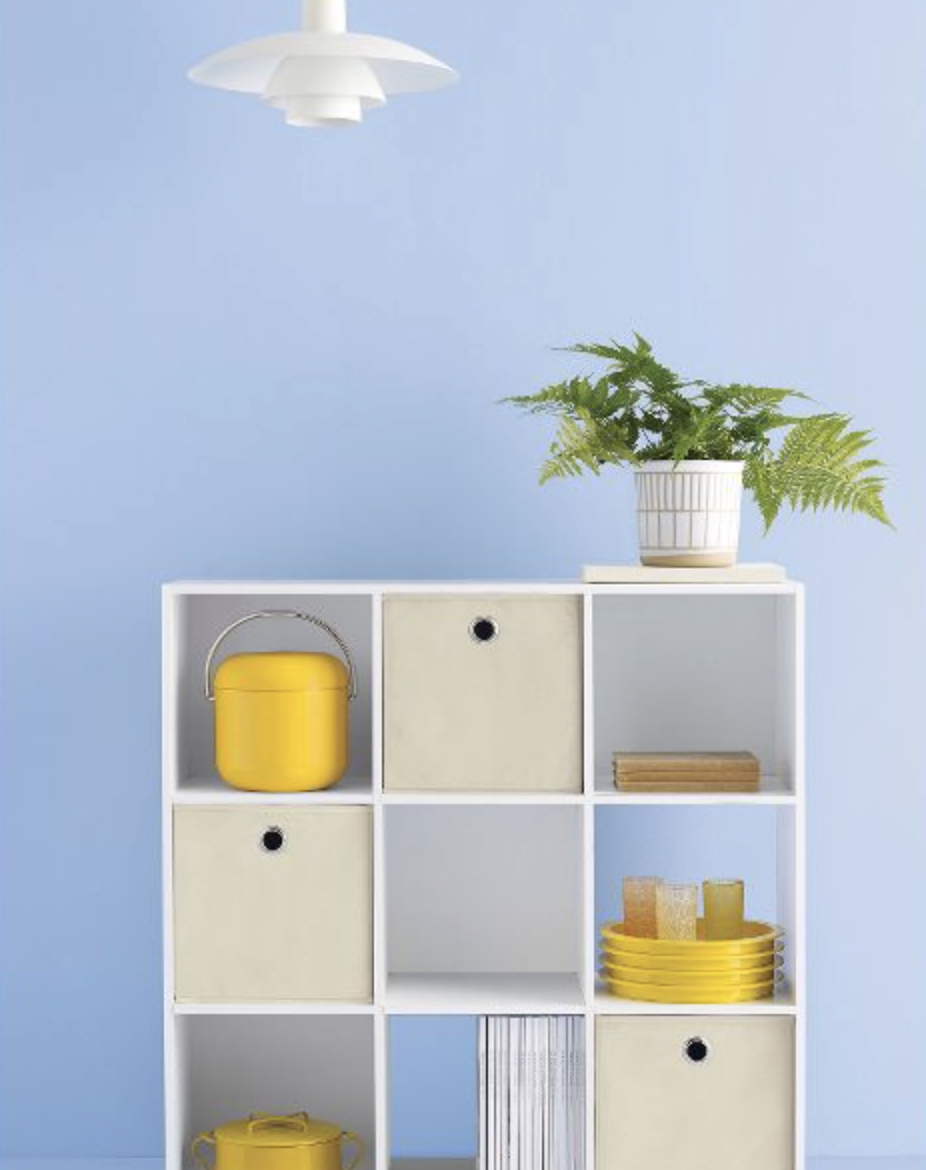 the white cube shelf, filled with storage boxes an other yellow trinkets