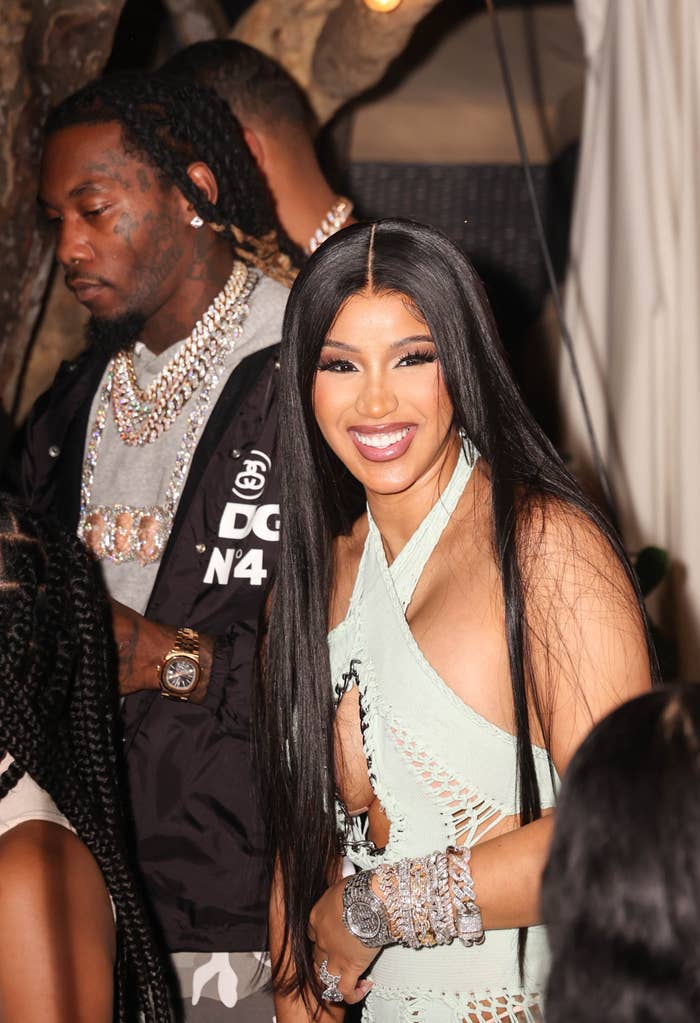 Cardi smiles as she stands next to Offset in a crowd