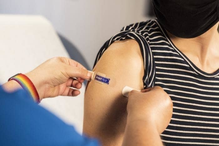 Healthcare professional puts bandaid on arm