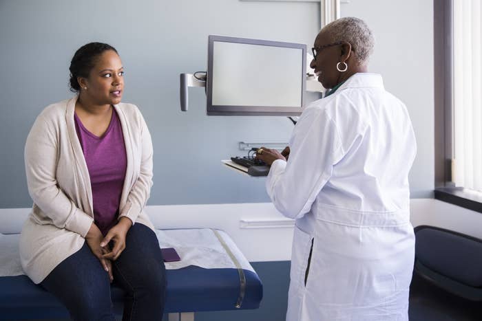 A Black doctor talking to her patient