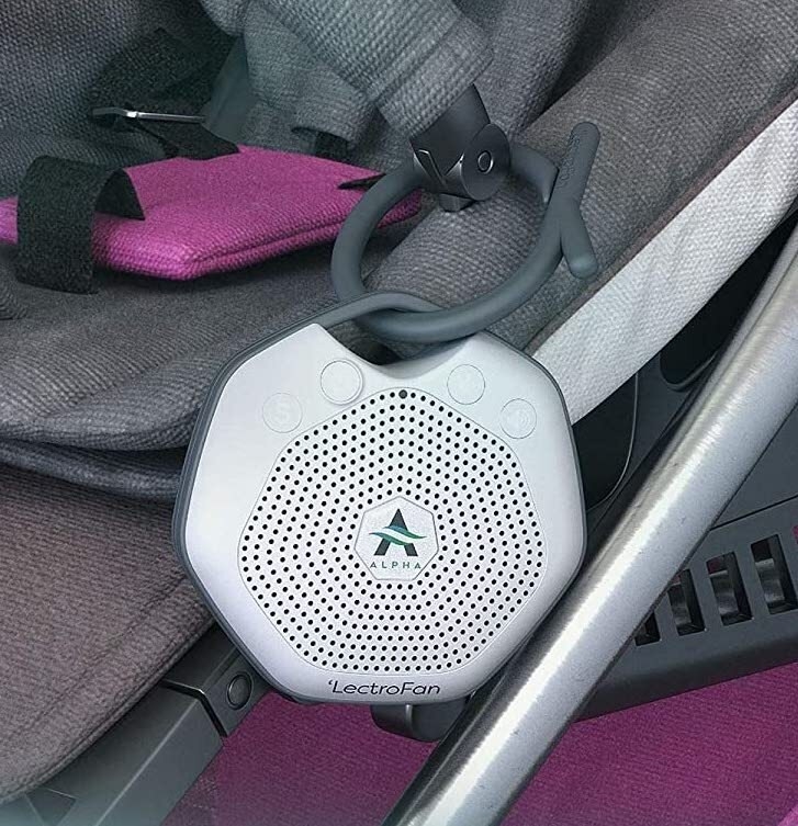 A white noise machine clipped to a seatbelt