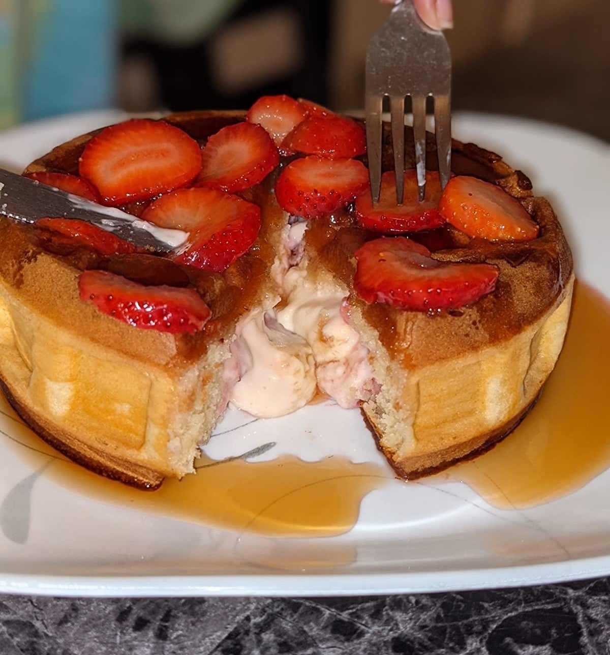 a reviewer&#x27;s stuffed waffle with strawberries on top