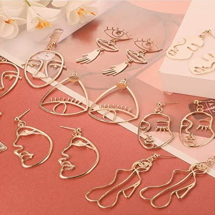 the gold face, body, and eye-shaped earrings