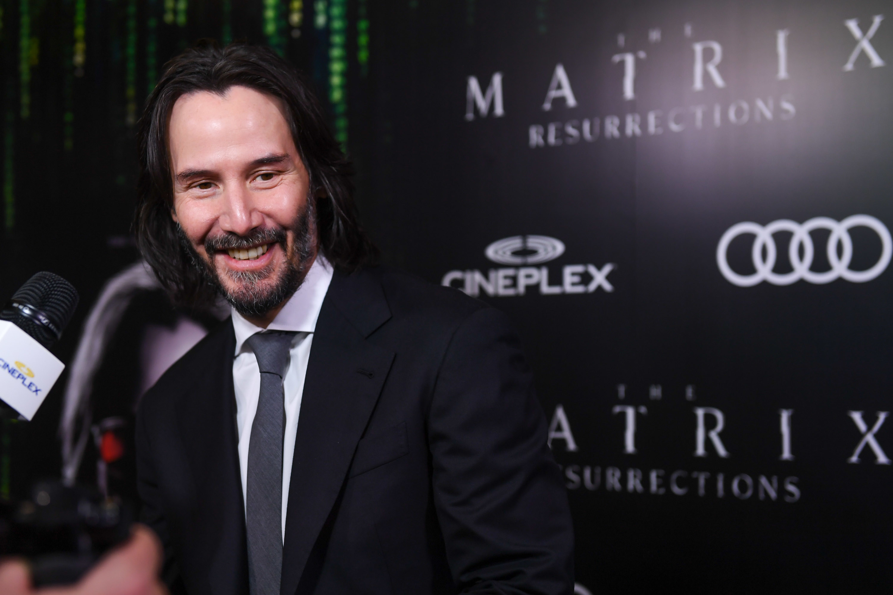 Keanu smiles at a red carpet event