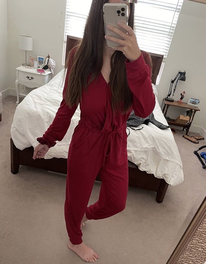 A reviewer wearing a red long-sleeved jumpsuit