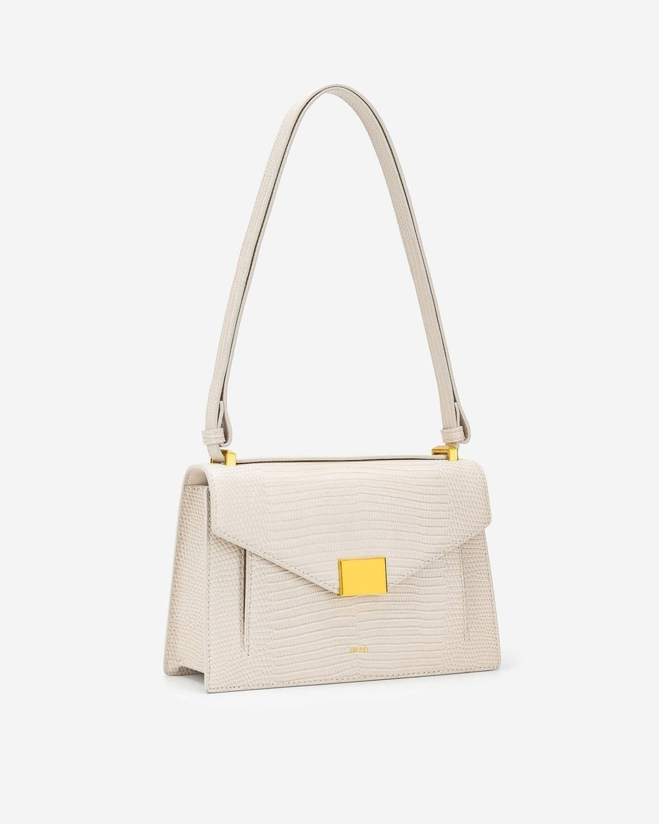 white structured bag with shoulder strap and gold hardware