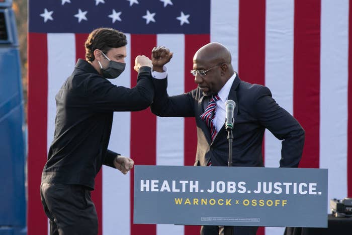 Election winners Jon Ossoff and Raphael Warnock bumping elbows at a rally
