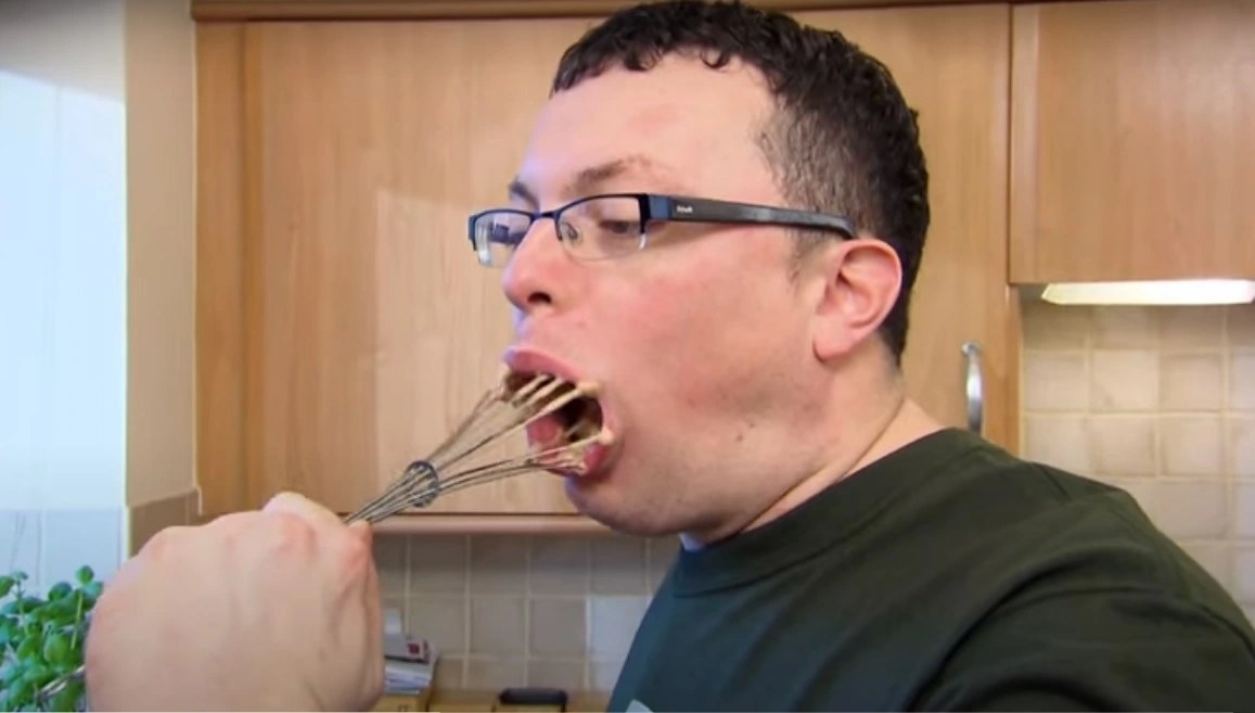 come dine with me contestant Kev putting a whisk in his mouth.