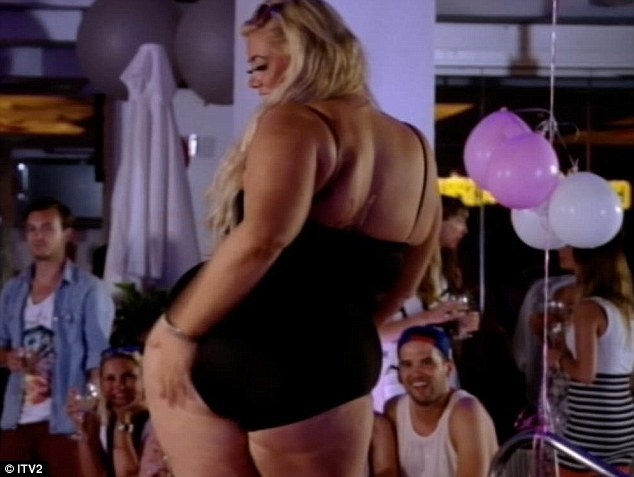 gemma collins walking next to a pool in a swimsuit while onlookers smile