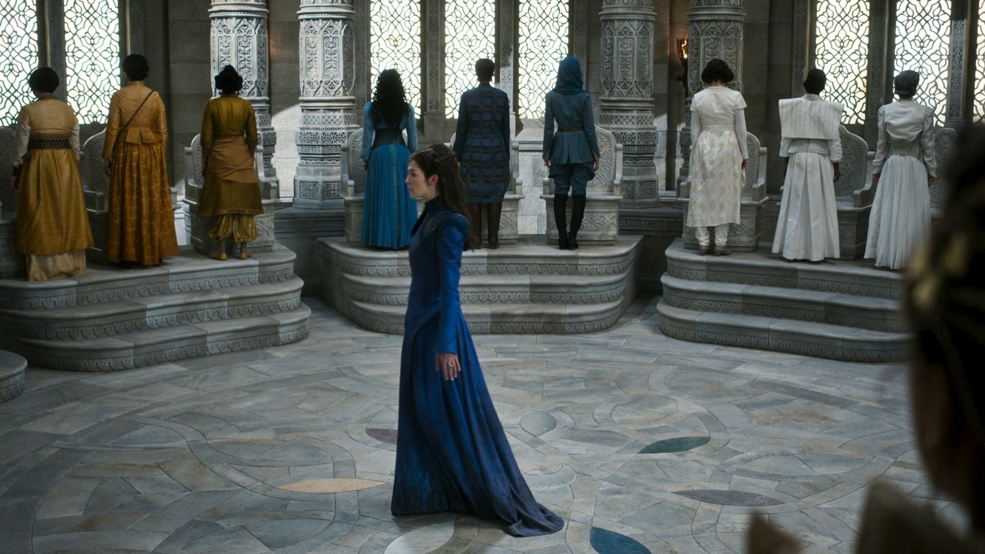 Moiraine turning and leaving the white-marbled hall of the Tower. She is striding away, head held high, though all the Sitters of the different Ajahs are standing and turning away from her