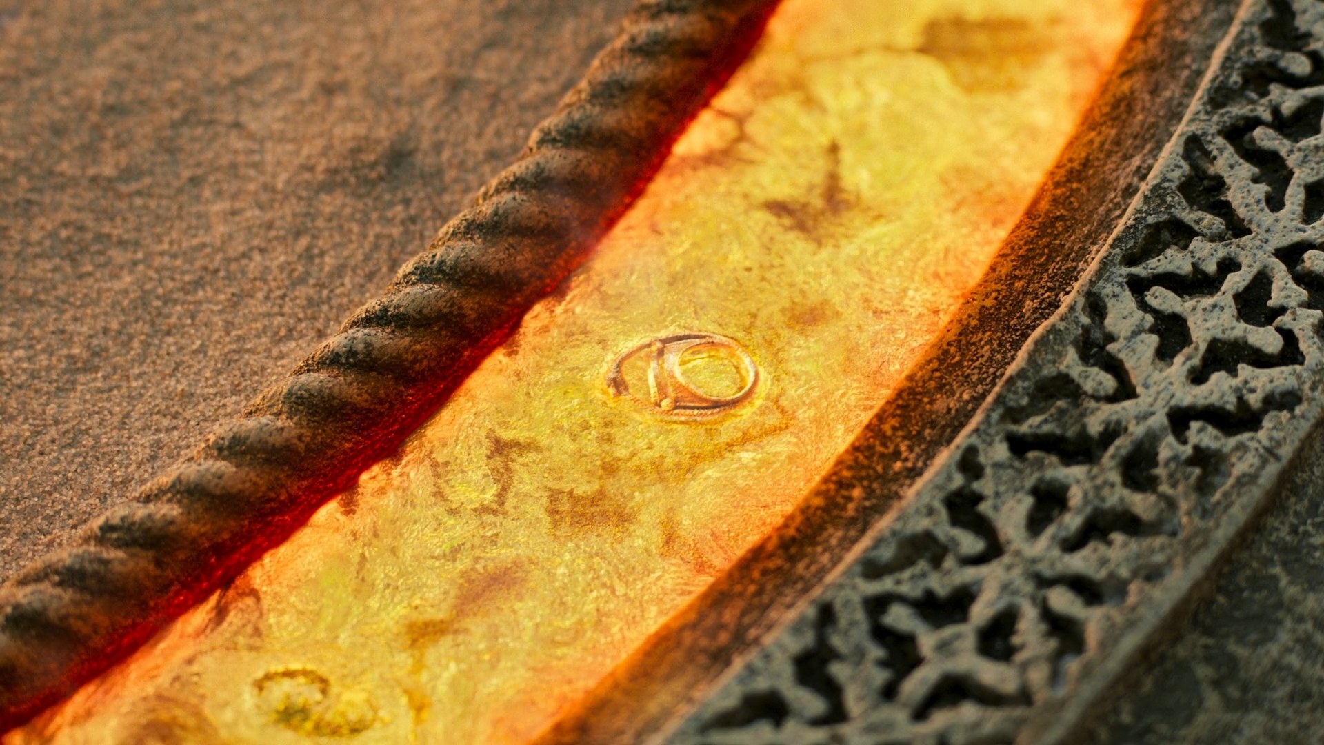 An extreme close-up of a pool of molten gold – an Aes Sedai ring with the gemstone removed, has been dropped into it, and is melting into the pool.
