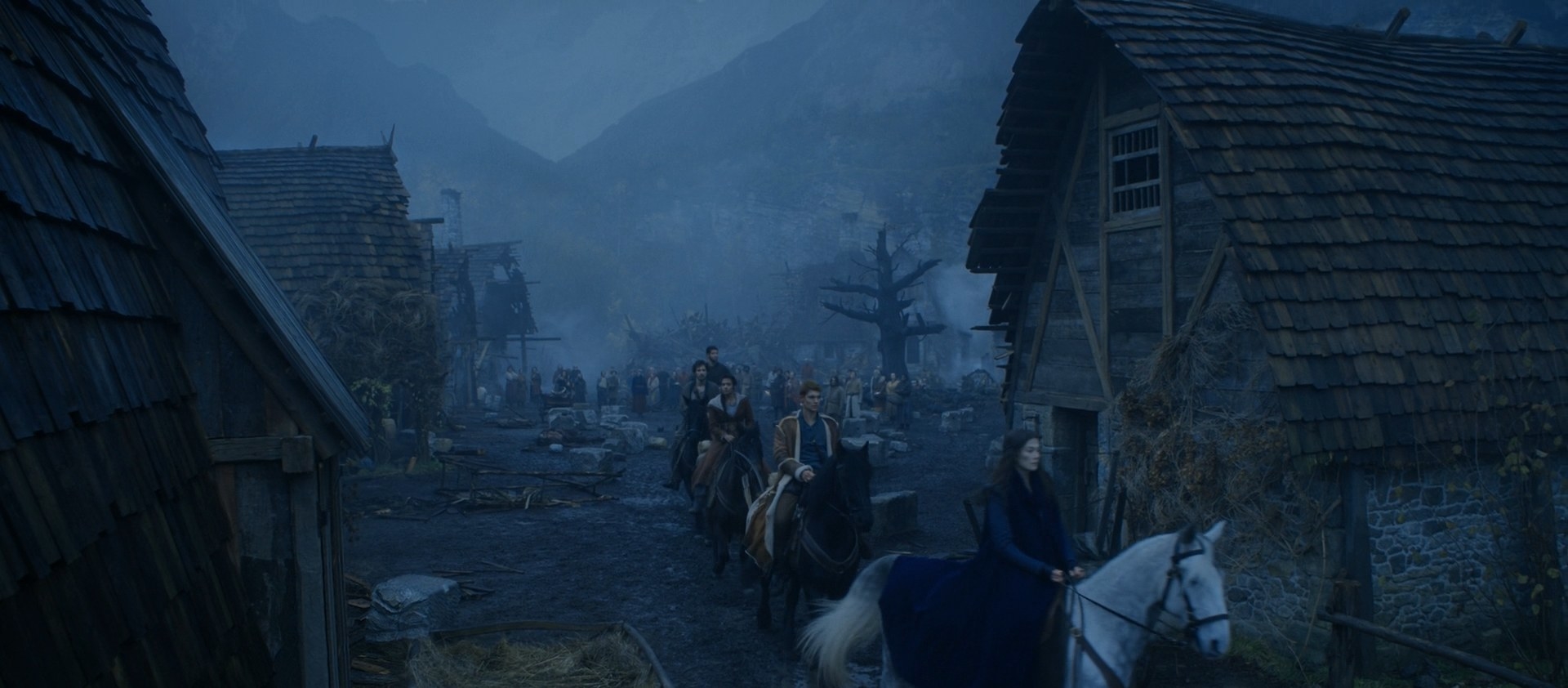 5. A long-shot from behind the burned-out Winespring Inn. Moiraine (Rosamund Pike) is on horseback, as is Rand, Egwene (Madeleine Madden), Mat (Barney Harris), and Perrin (Marcus Rutherford) as they leave the Two Rivers.