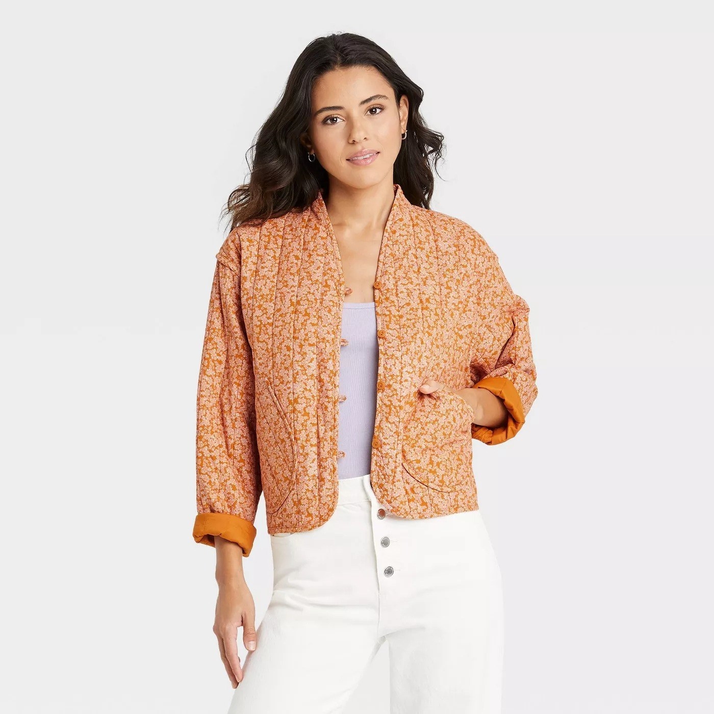 Model wearing orange floral patterned jacket with two front pockets