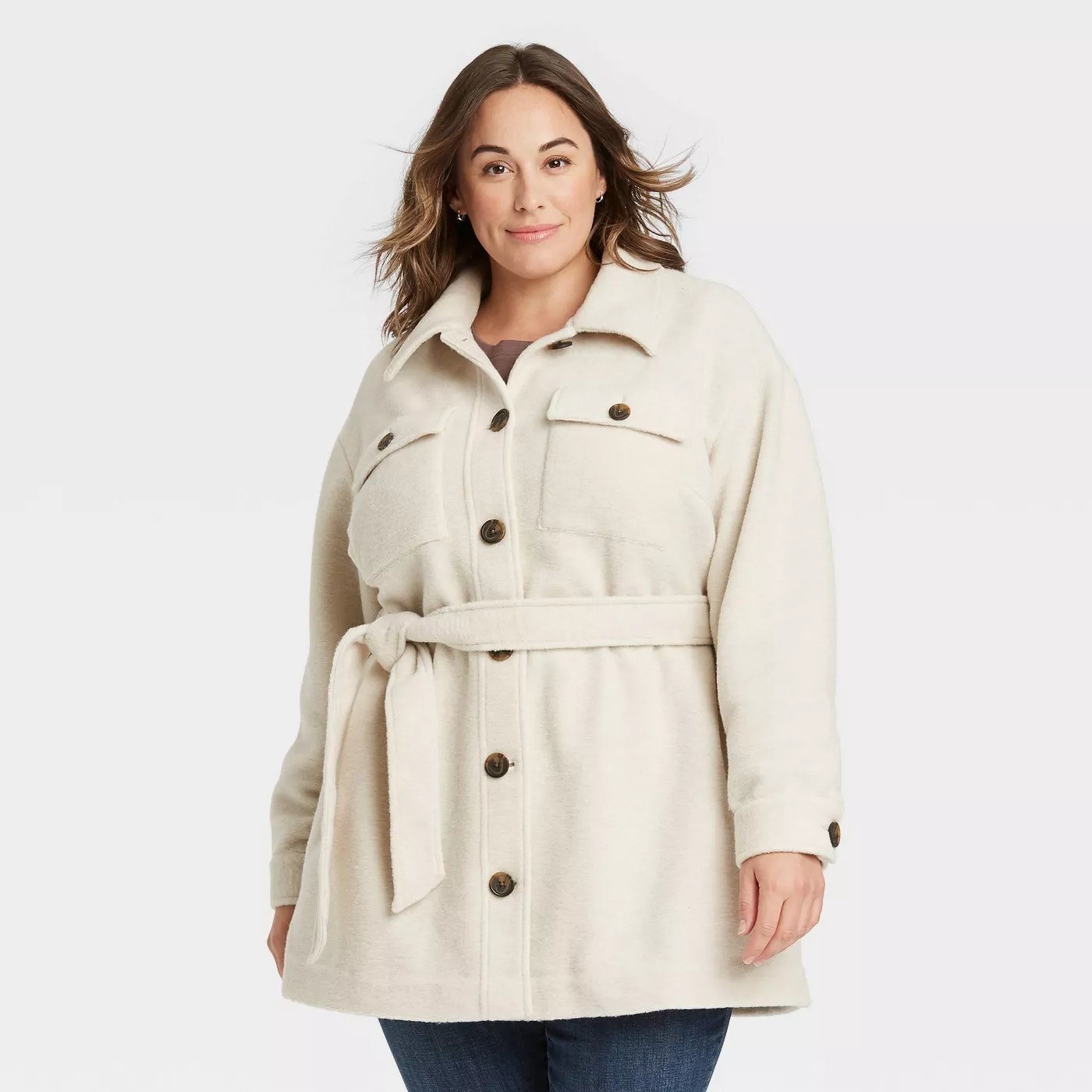 Model wearing cream colored jacket with brown buttons