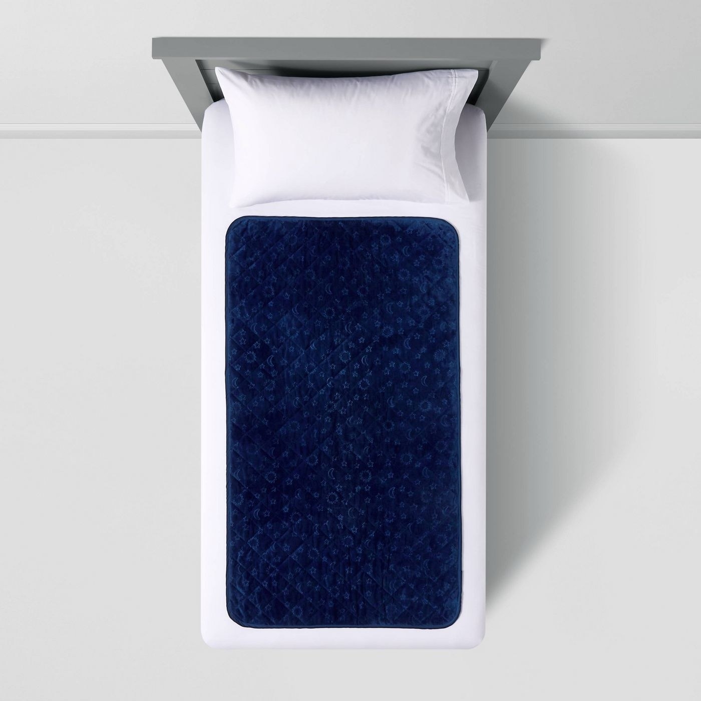 A blue sleep pad on a white bed