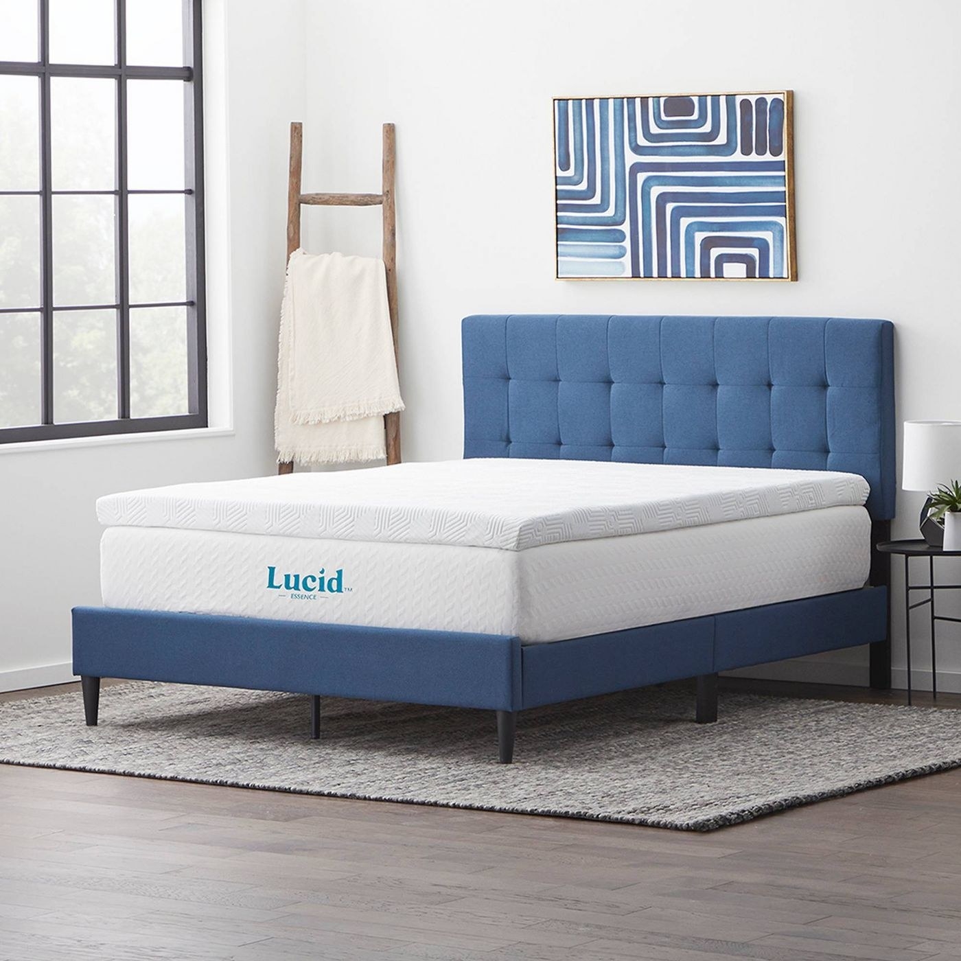A mattress topper on a white mattress in a blue bed.