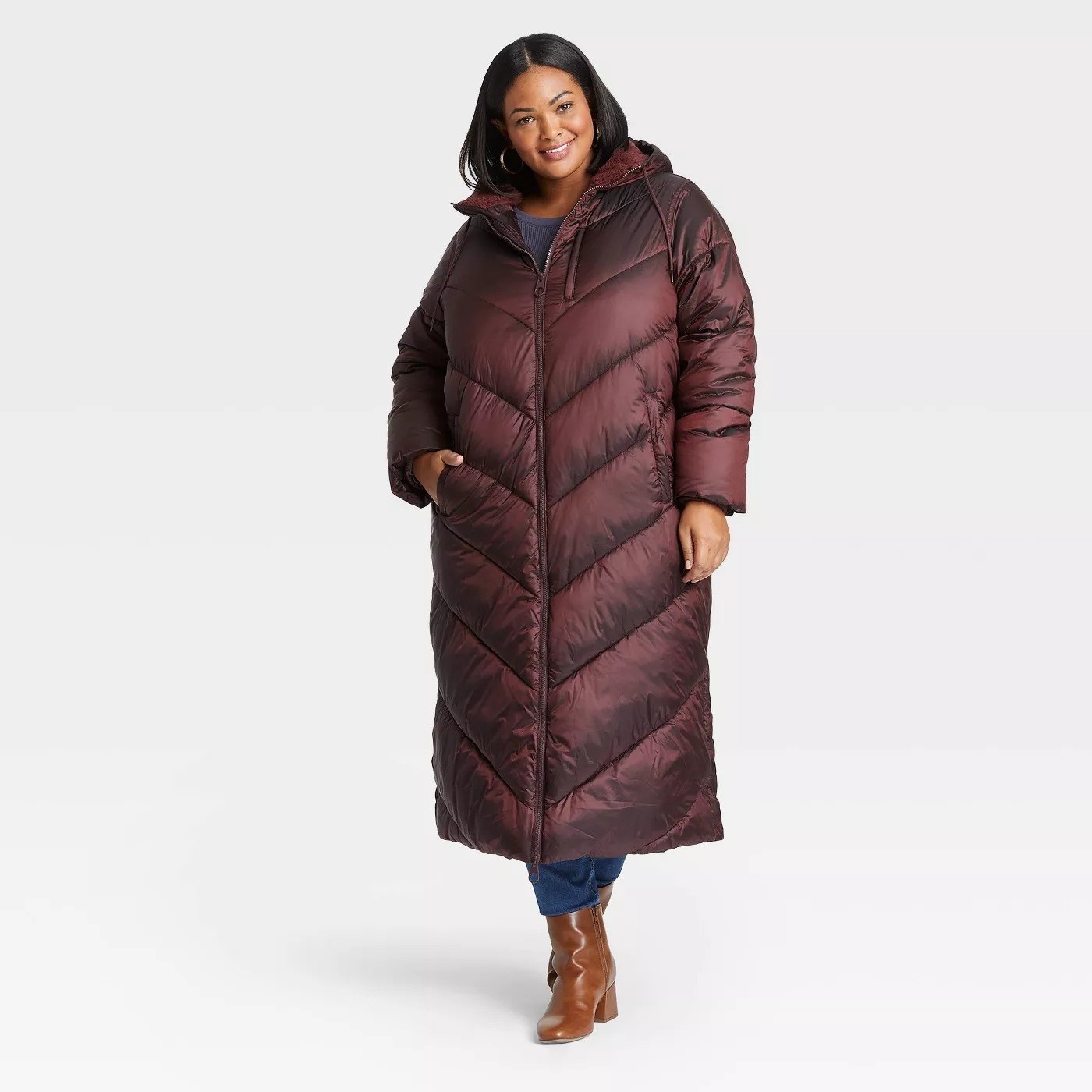 Model wearing burgundy coat with pockets, stops above the knee