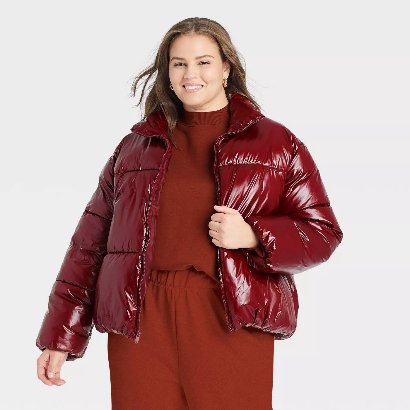 Model wearing red puffy jacket, goes past the waist