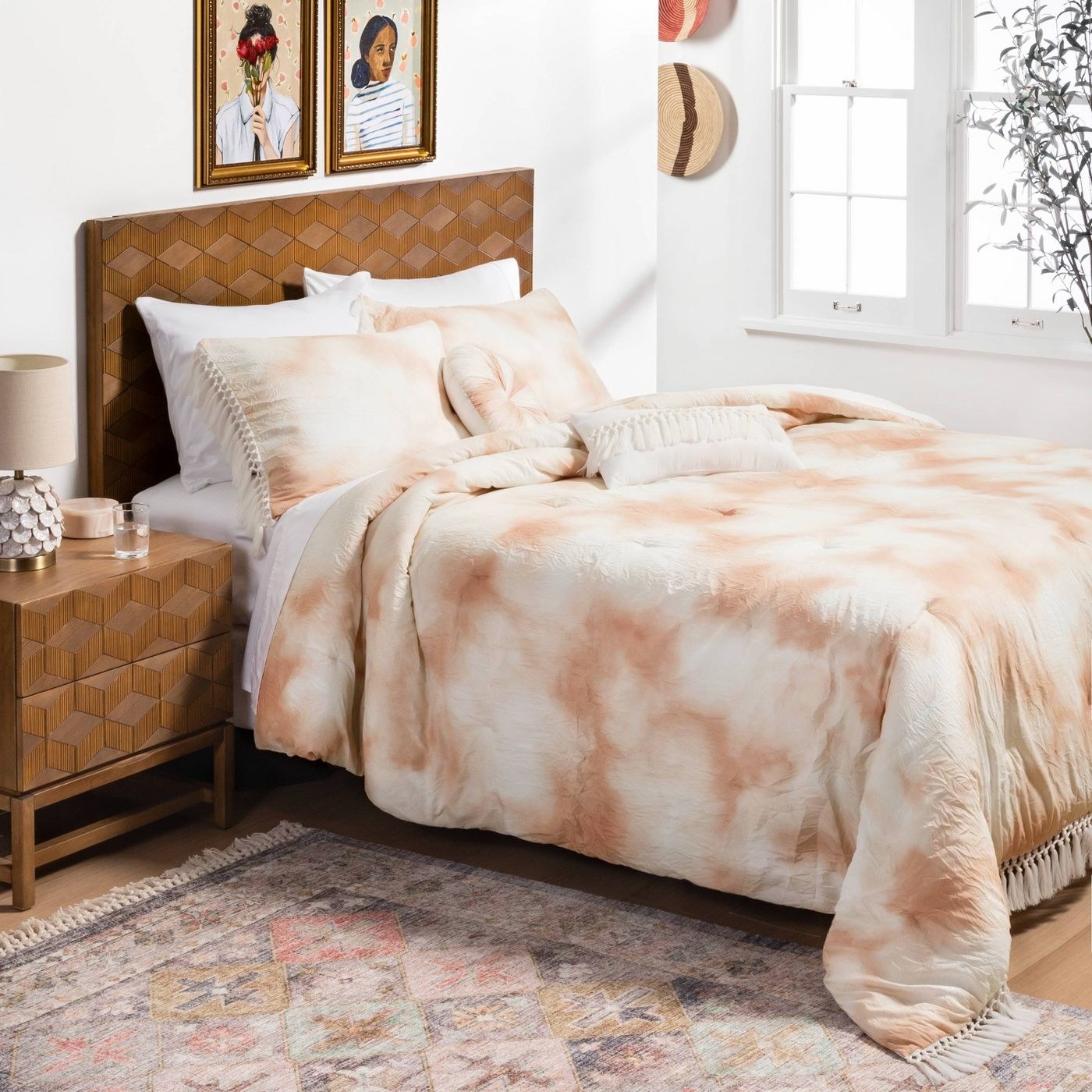 A wooden bedroom set with a taupe tie-dye comforter