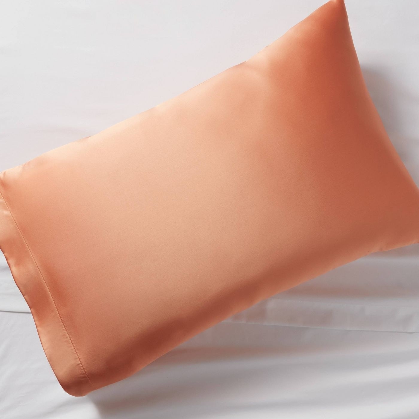 A peach colored silk pillow case