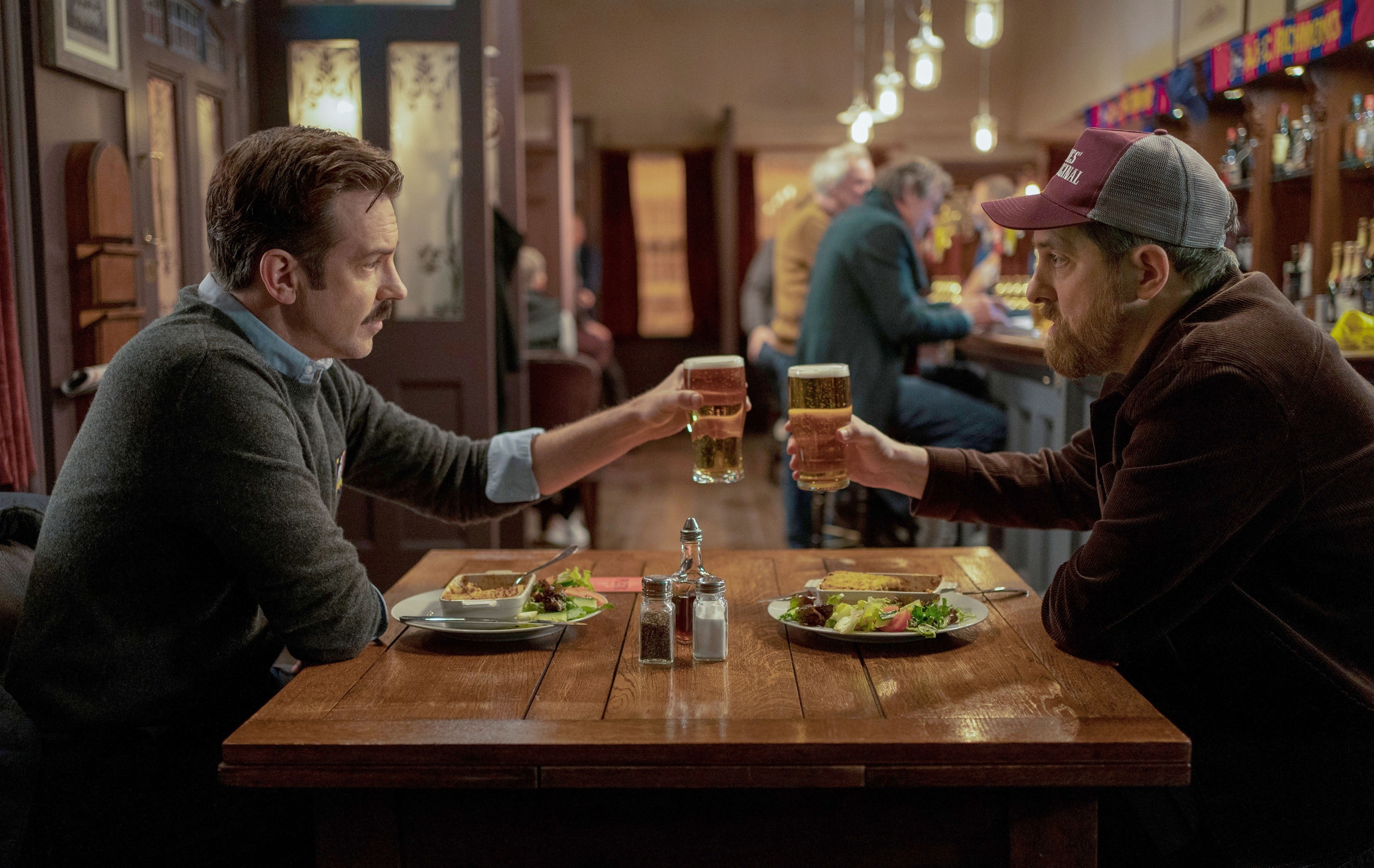 TED LASSO, from left: Jason Sudeikis, Brendan Hunt, (Season 2, ep. 201, aired July 23, 2021).