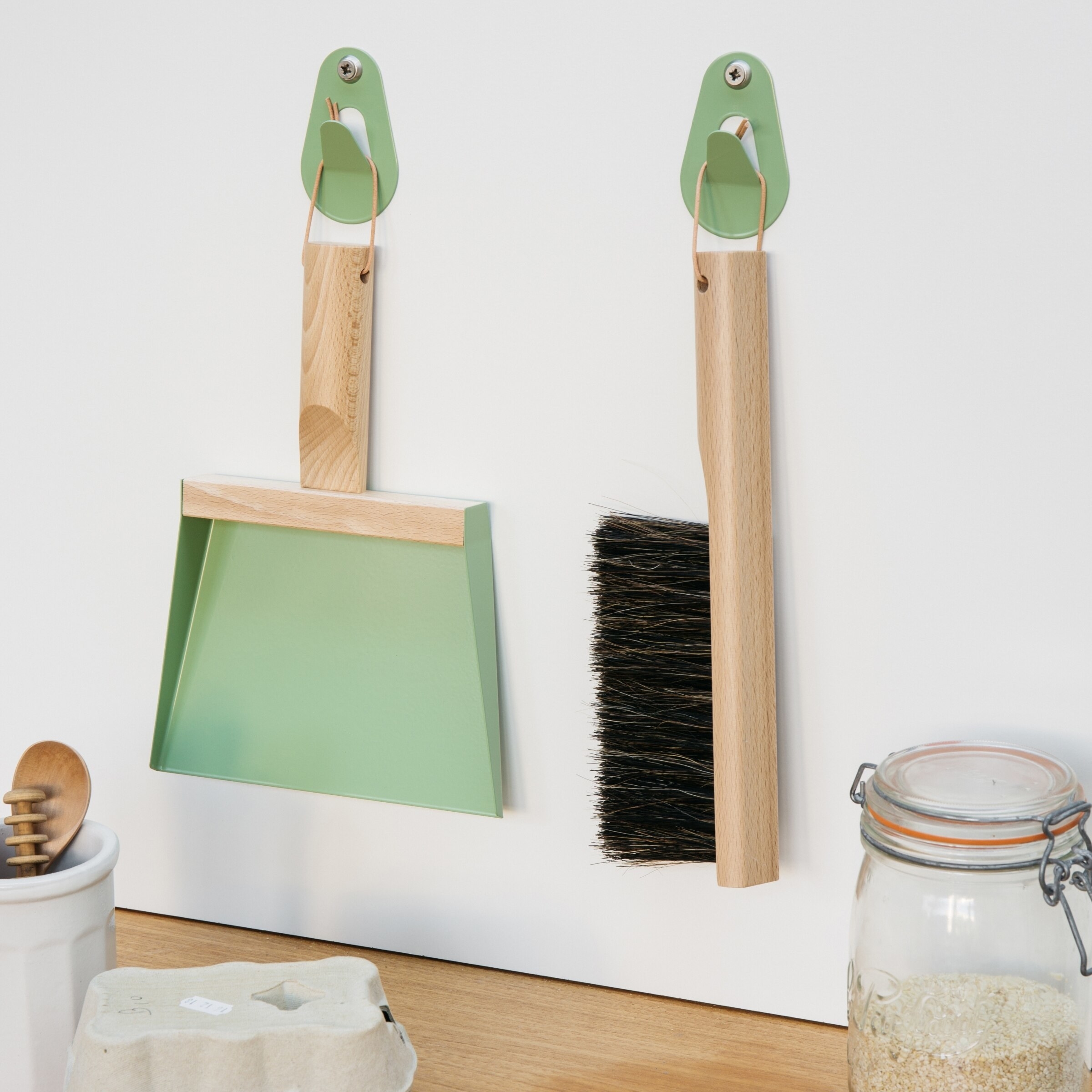 the dustpan and broom hung on matching hooks