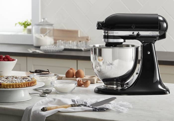 The stand mixer on a kitchen counter surrounded by baking ingredients
