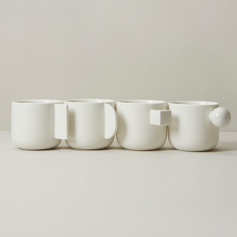 a set of four ceramic mugs with different handles