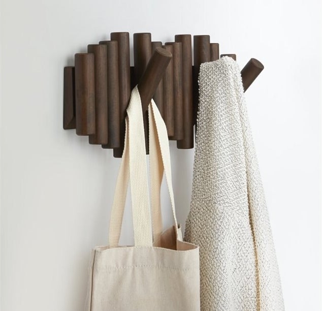 the wall hook holding a jacket and canvas bag